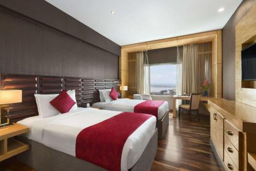 Giường trong phòng chung tại Ramada by Wyndham Alleppey