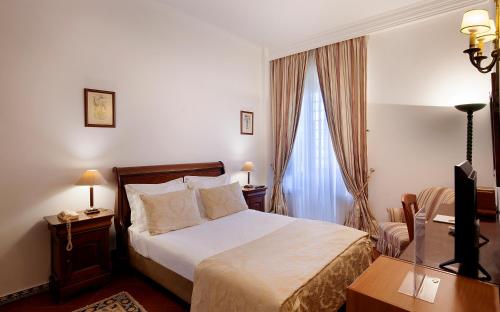 a hotel room with a bed and a window at Turim Club Azeitao Hotel in Setúbal