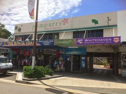 ein Gebäude mit Schildern an der Straßenseite in der Unterkunft Whitehaven Beachfront Holiday Units in Airlie Beach