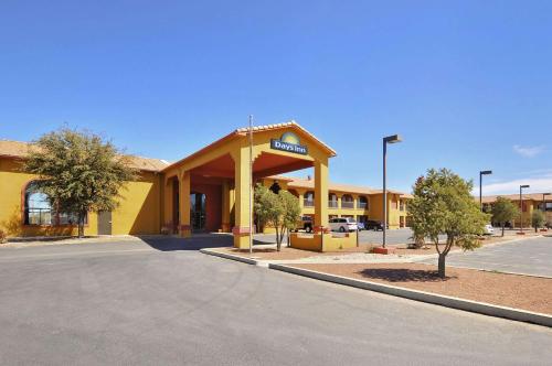 un bâtiment jaune avec station-service dans un parking dans l'établissement Days Inn by Wyndham Carlsbad, à Carlsbad