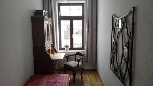 Cette chambre comprend un bureau, une fenêtre et une chaise. dans l'établissement Bastians Herberge, à Leipzig