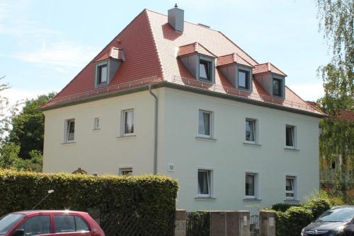 una gran casa blanca con techo rojo en Ferienwohnung Holl, en Bayreuth