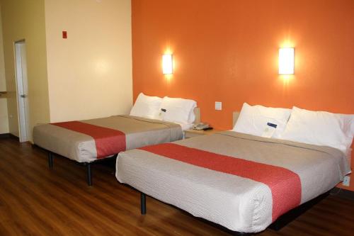 duas camas num quarto de hotel com paredes cor de laranja em Motel 6-Warwick, RI - Providence Airport - I-95 em Warwick