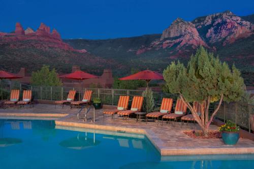 een zwembad met stoelen en parasols met bergen op de achtergrond bij Hyatt Vacation Club at Pinon Pointe, Sedona in Sedona