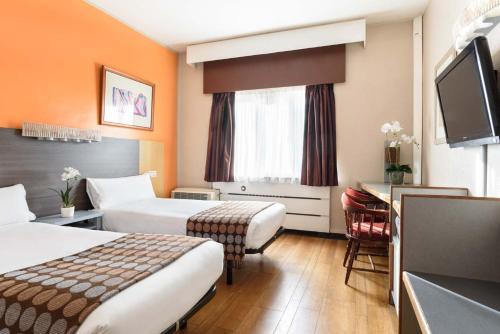 een hotelkamer met 2 bedden en een bureau bij Crisol Quindós in León