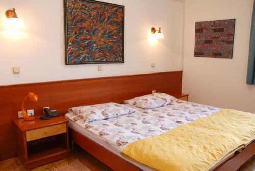 una camera con un letto e una foto appesa al muro di Guest House Arvaj a Kranj