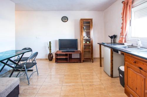 een woonkamer met een tafel en een televisie bij B Ensuite Appartment con Zona de Patio in Arrecife