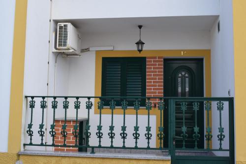 un balcone di una casa con porta verde di Refúgio d' Aldeia a Reguengos de Monsaraz