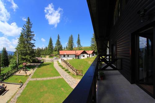 einen Balkon mit Blick auf ein Haus in der Unterkunft Pensiunea Rafael in Păltiniş