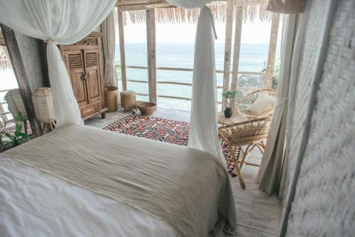 een slaapkamer met een bed en uitzicht op de oceaan bij Dreamsea Bali in Uluwatu