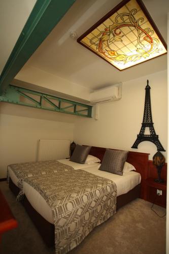 um quarto com duas camas e uma janela e a torre Eiffel em Hotel La Roseraie em Wemmel