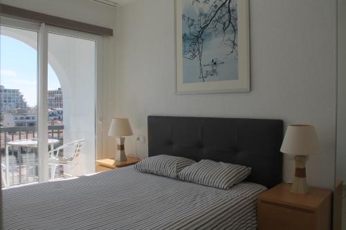 ein Schlafzimmer mit einem Bett und einem großen Fenster in der Unterkunft Absolute Apartment in Empuriabrava