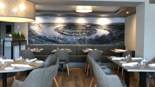 um restaurante com mesas e cadeiras e um quadro na parede em Landgasthof Eiserner Ritter em Boppard