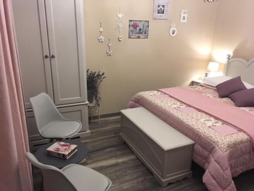 a bedroom with a pink bed and a chair at Shabby chic rooms in Zadar