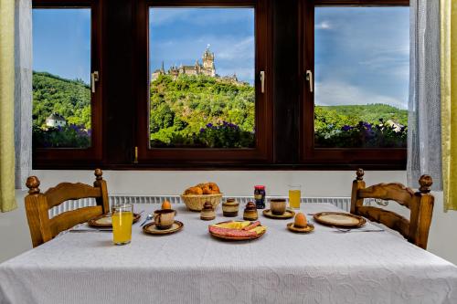 a table with food and a view of a castle at Apartments Haus Daniela in Cochem