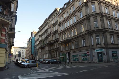 une rue de la ville avec des voitures garées devant les bâtiments dans l'établissement Ada Aparthouse, à Wrocław