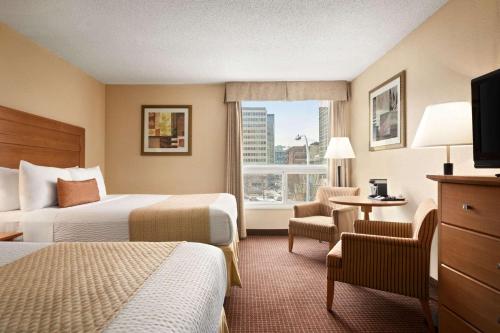 Un pat sau paturi într-o cameră la Days Inn by Wyndham Edmonton Downtown