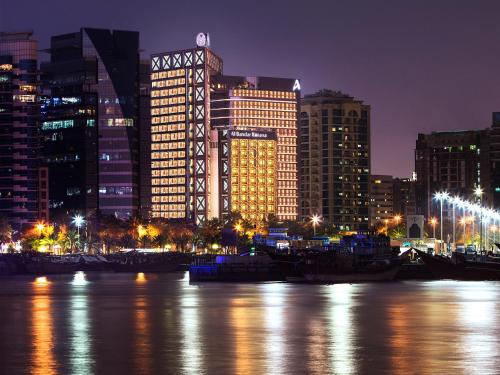 a city panorama at night with boat in the water w obiekcie Al Bandar Rotana – Dubai Creek w Dubaju