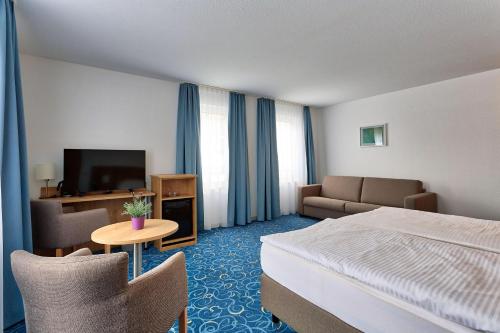 una camera d'albergo con letto e TV di Appartis - Hotel am Stadtpark a Sindelfingen