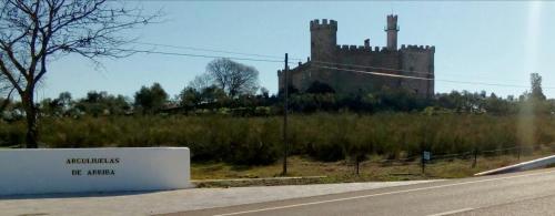 um velho castelo sentado ao lado de uma estrada em Casa Rural Castillo de Cáceres em Cáceres