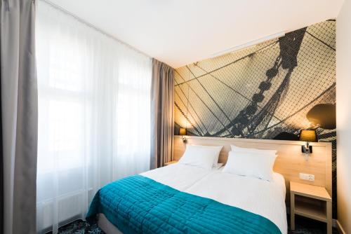 um quarto com uma cama e um quadro na parede em Hotel Eureka em Sopot