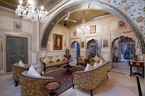 Großes Zimmer mit Stühlen und einem Kronleuchter in der Unterkunft Alsisar Haveli - Heritage Hotel in Jaipur