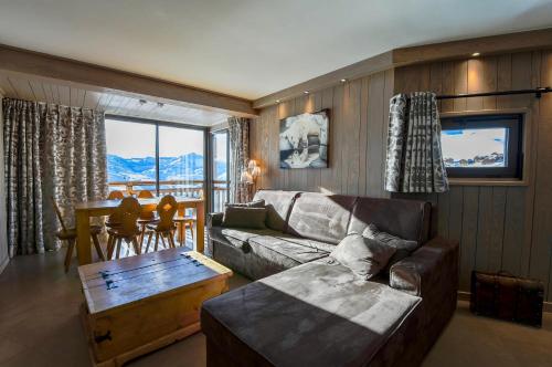 a living room with a couch and a table at A21 Roc de Péclet in Val Thorens