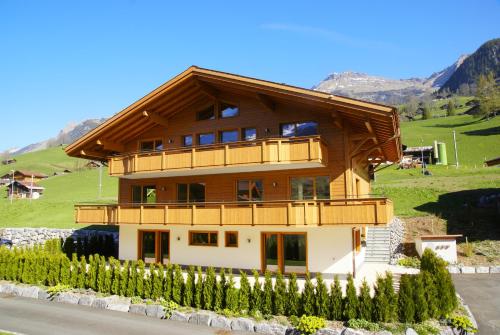 duży drewniany dom z balkonem w obiekcie Chalet Rothenegg - GRIWA RENT AG w mieście Grindelwald