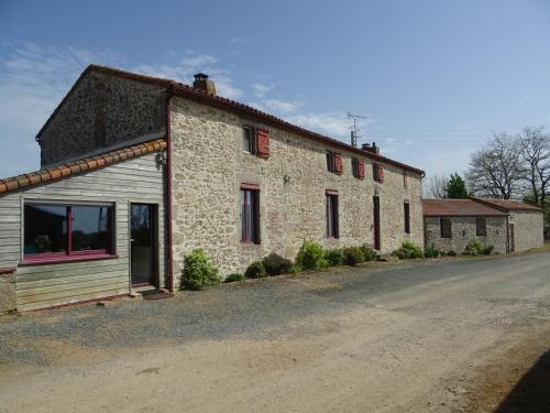 una casa in pietra su una strada sterrata vicino a una strada di La Lauriére a Treize-Vents