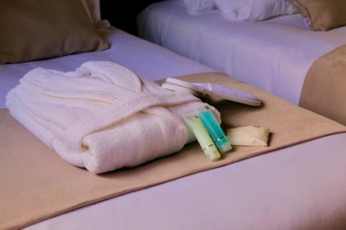 a towel on a bed with medicines and a razor at Calypso Home Oran in Oran