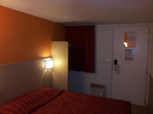 A bed or beds in a room at Premiere Classe Lyon Est Aeroport Saint Exupery