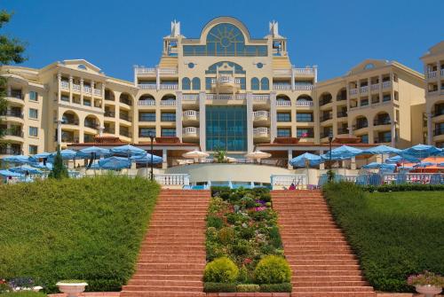 een groot gebouw met blauwe parasols ervoor bij Duni Marina Royal Palace Hotel - Ultra All Inclusive in Sozopol