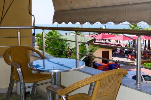 a table and chairs on a balcony with a view of the beach at Comfortable apartment next to the beach in Durrës