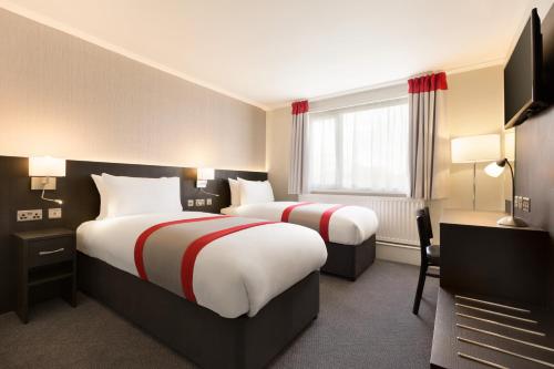 A bed or beds in a room at Ramada Chorley South