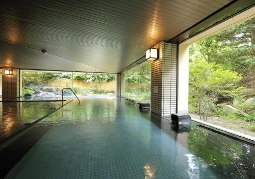 een huis met een zwembad in een kamer bij Higashiyama Park Hotel Shinfugetsu in Aizuwakamatsu