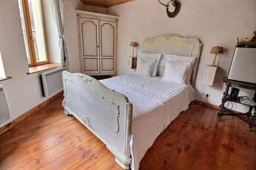 a bedroom with a white bed with a wooden floor at Golden Lion in Bouillon