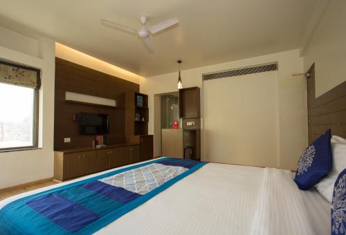 1 dormitorio con 1 cama grande y ventilador de techo en Corporate Stay, en Pune