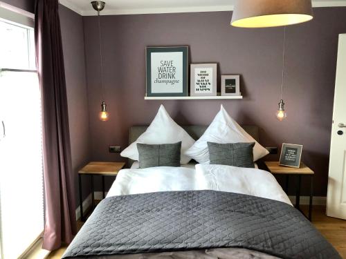 um quarto com uma cama grande e uma parede roxa em Boutique Hotel Lindenhof, Bed & Breakfast em Aurich