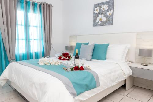 Un dormitorio con una gran cama blanca con toques azules en Margarita Hotel, en Firostefani