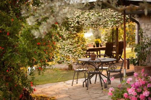 a table and chairs in a garden with flowers at Tenuta Di Canonica in Todi