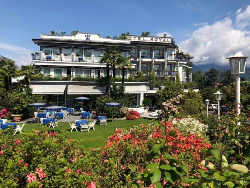 un hotel con giardino con sedie e fiori di Hotel Royal a Stresa