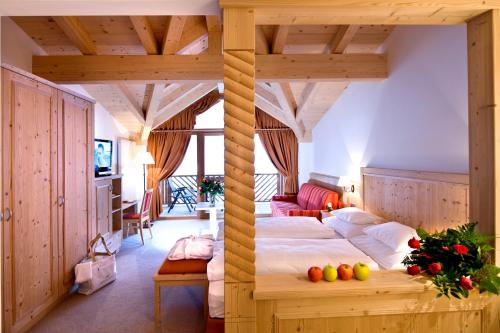 two images of a bedroom with a bed in a room at Hotel Chalet Tianes - Alpine Relax in Castelrotto