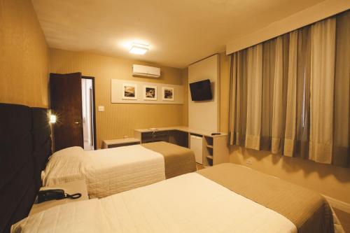 Cama ou camas em um quarto em Curitiba Palace Hotel