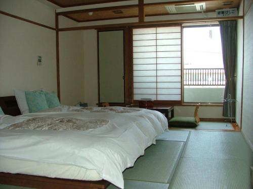 Een bed of bedden in een kamer bij Miyajima Hotel New Kotobuki