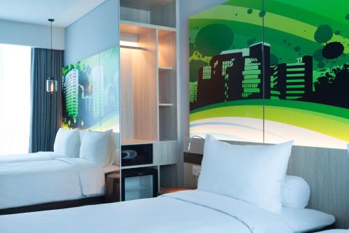 A bed or beds in a room at The Southern Hotel Surabaya Formerly Ibis Styles Surabaya Jemursari