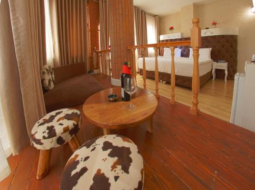 a bedroom with a bed and a table and chairs at The Red Bricks Hotel in Shkodër