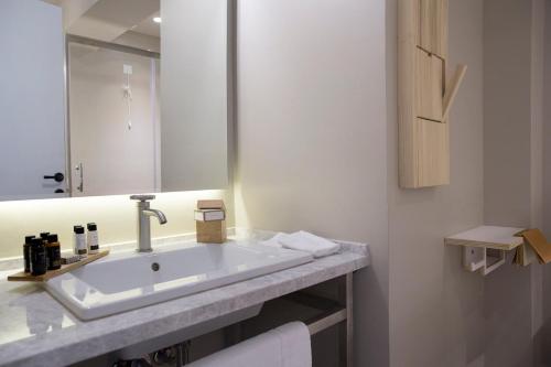 a bathroom with a sink and a mirror at Apollon Library Suites in Nafpaktos