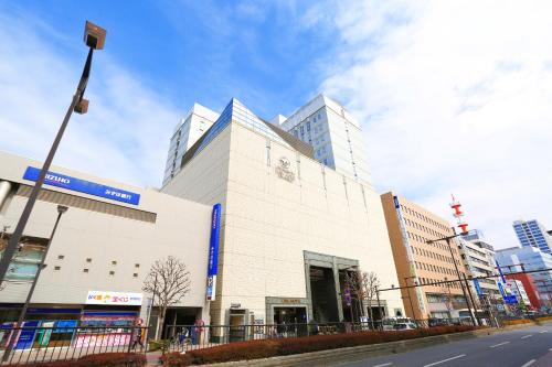 un grande edificio bianco su una strada cittadina di Utsunomiya Tobu Hotel Grande a Utsunomiya