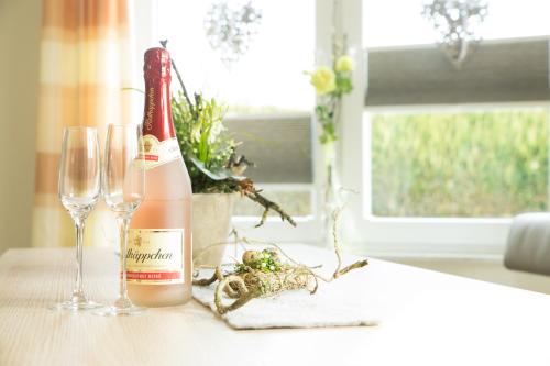 a bottle of wine and two glasses on a table at Gästehaus Marichen in Aurich