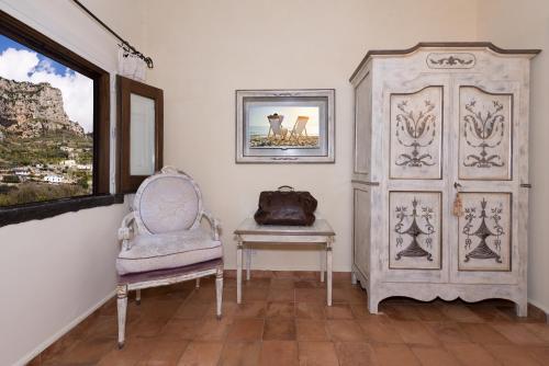 Habitación con silla, mesa y puerta en Villa Alba d'Oro, en Amalfi